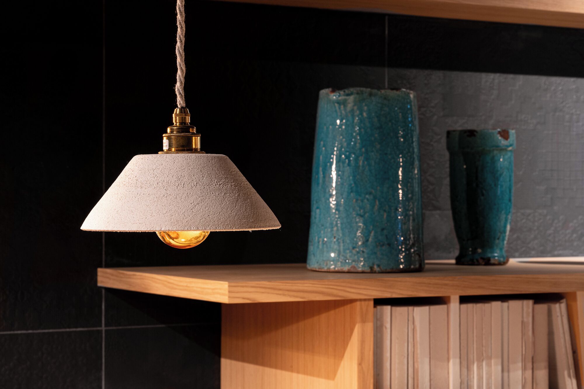 A pendant light with a textured shade hanging from a ceiling.