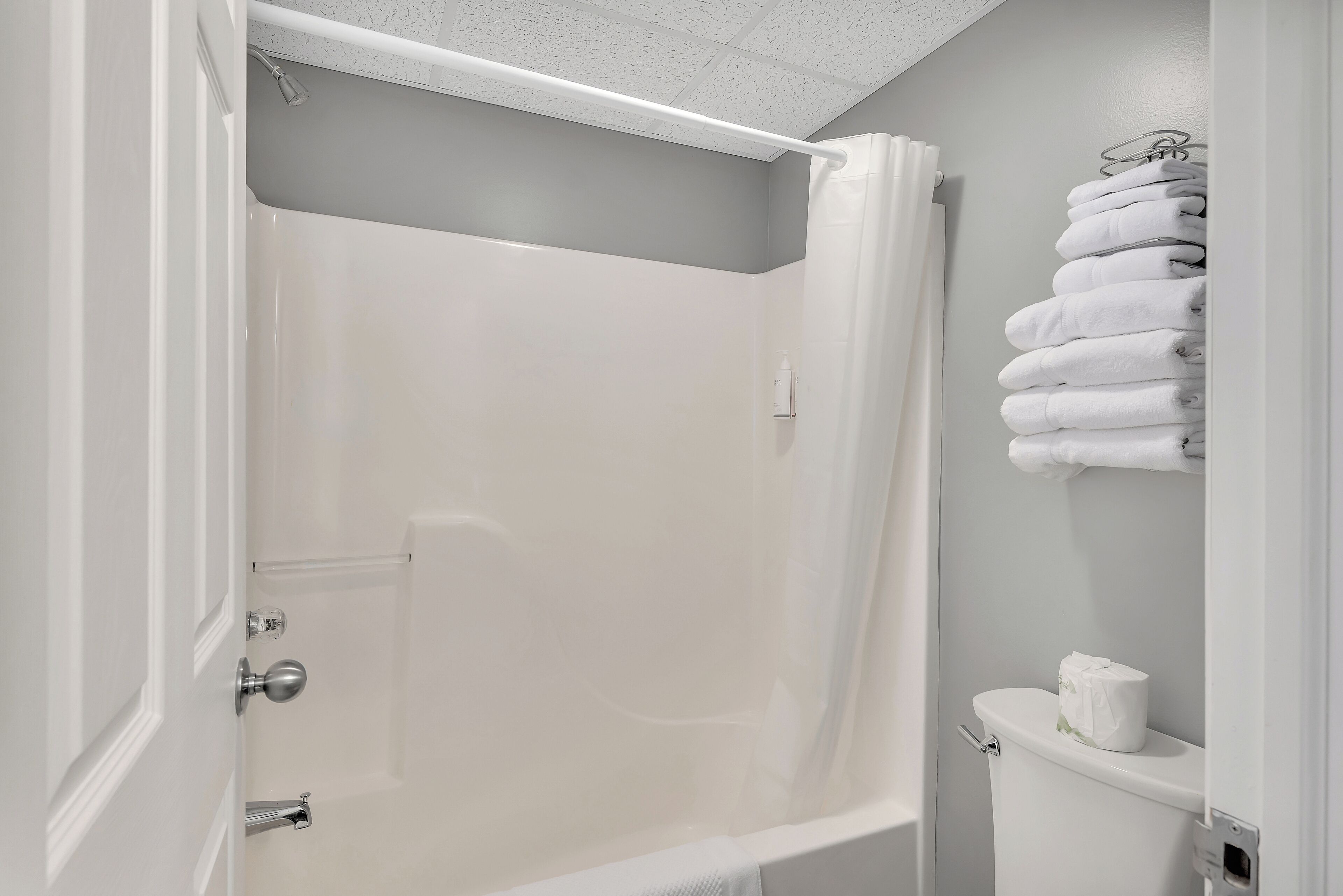Un baño con ducha, inodoro y perchero para toallas.