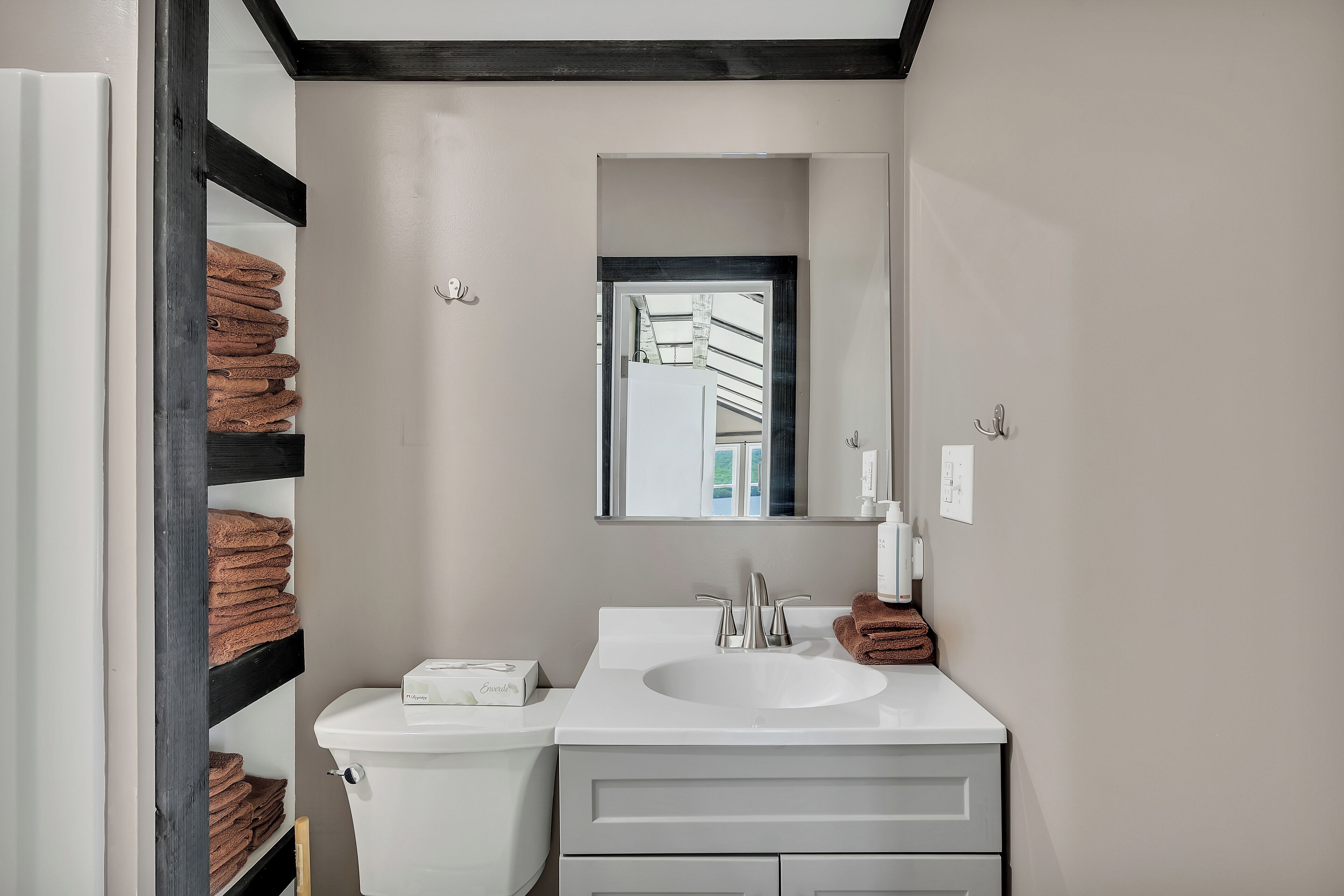 A bathroom with a white sink, a mirror, and a towel rack.