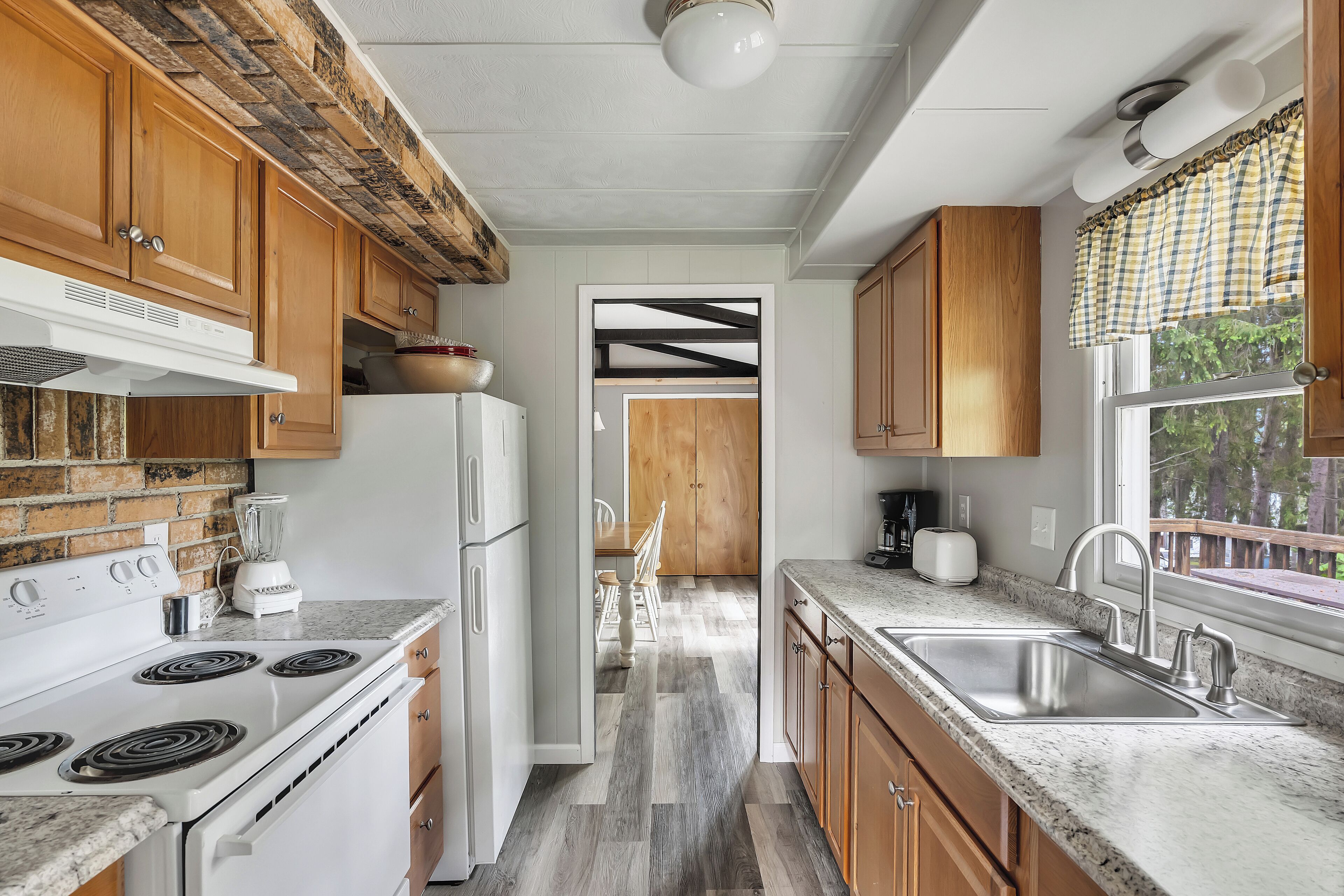 A kitchen with wooden cabinets, a white stove, and a granite countertop.