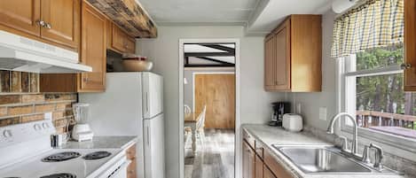 A kitchen with wooden cabinets, a white stove, and a granite countertop.