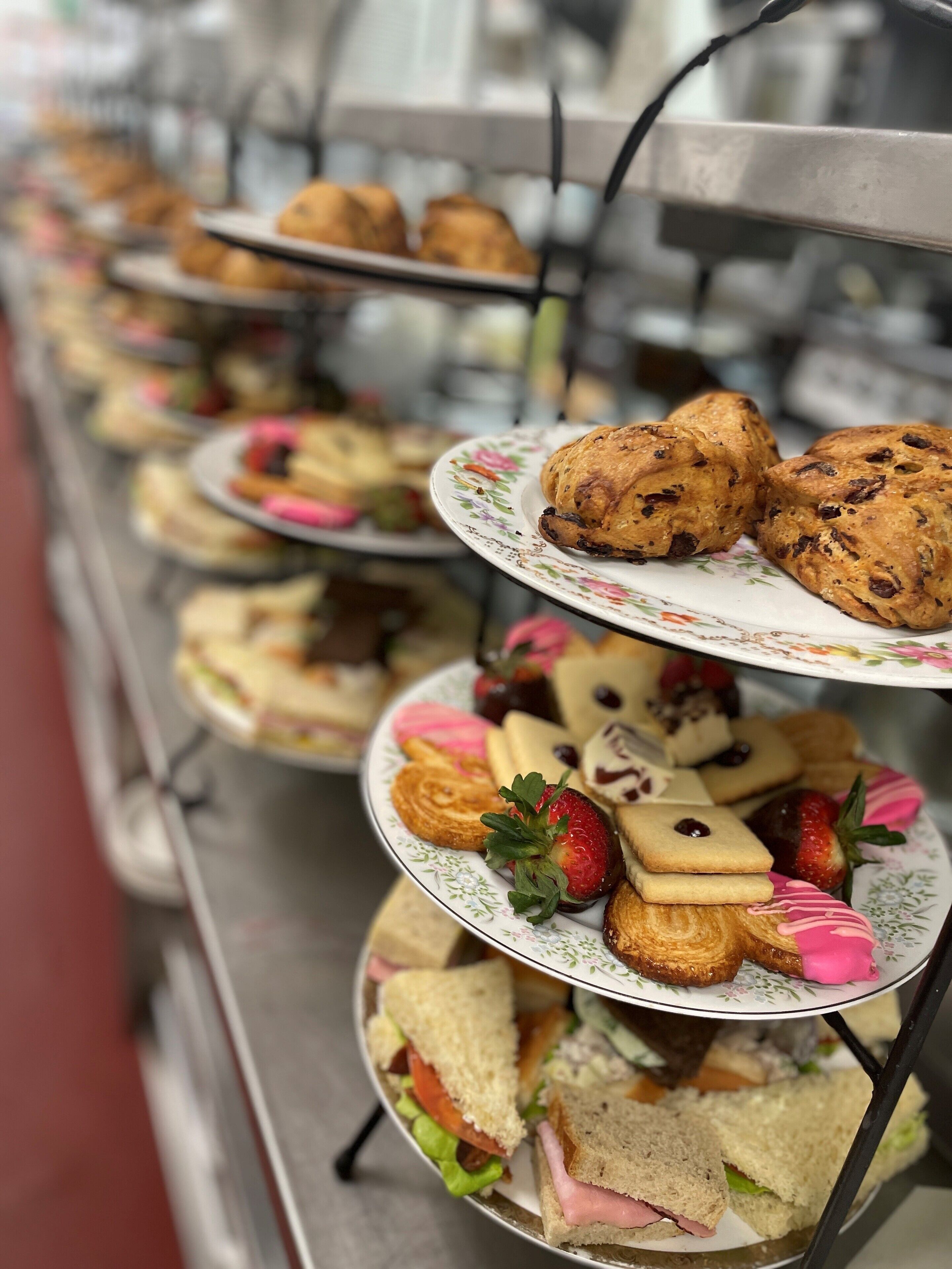 A buffet with various food items including sandwiches, pastries, and fruit.