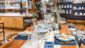 A restaurant with wooden interiors, a long dining table set for a meal, and various dishes and glasses on the table. - Six South St Hotel (Hanover)