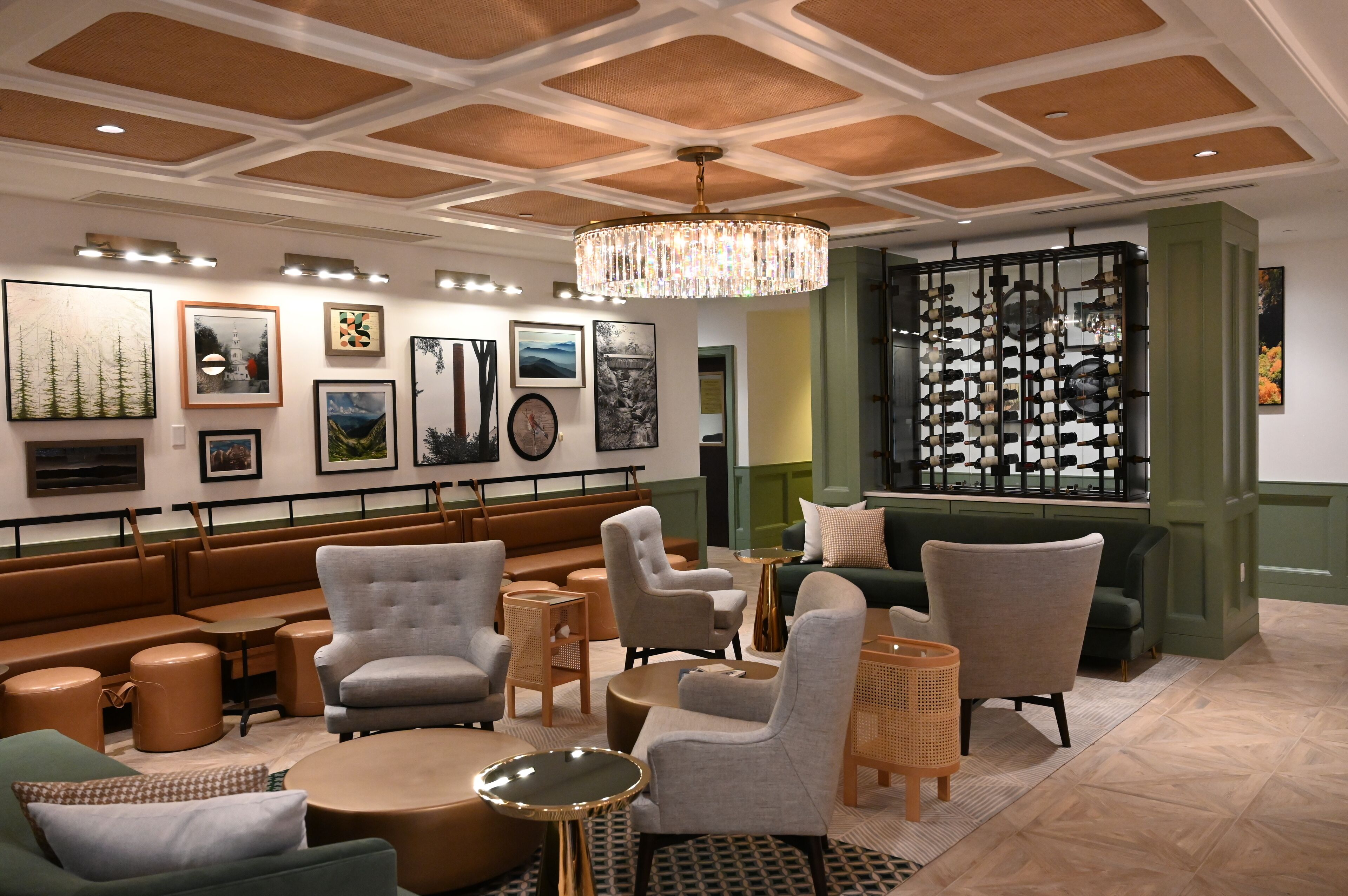 A modern lounge area with seating arrangements, artwork on the walls, and a decorative partition.