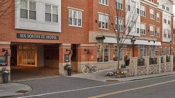 A multi-story brick building with a sign reading "Six South St. Hotel".