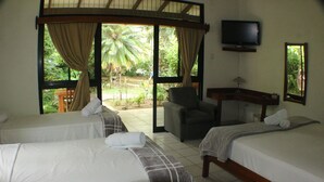 A hotel room with two beds, a TV, a desk, and a chair.