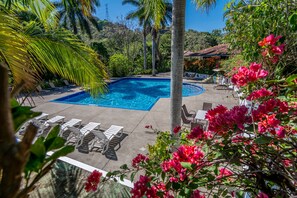 A pool area with lounge chairs and a view of the surrounding greenery. - Hotel Colinas del Sol (Atenas)
