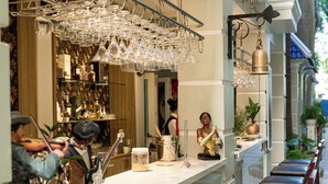 A bar area with stools, a counter with glassware, and decorative items. - Eden Plaza Danang (Da Nang)