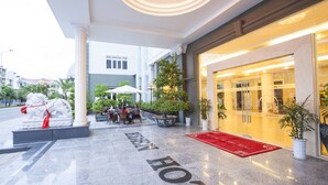 A hotel entrance with a red carpet, a statue, and outdoor seating. - Eden Plaza Danang (Da Nang)