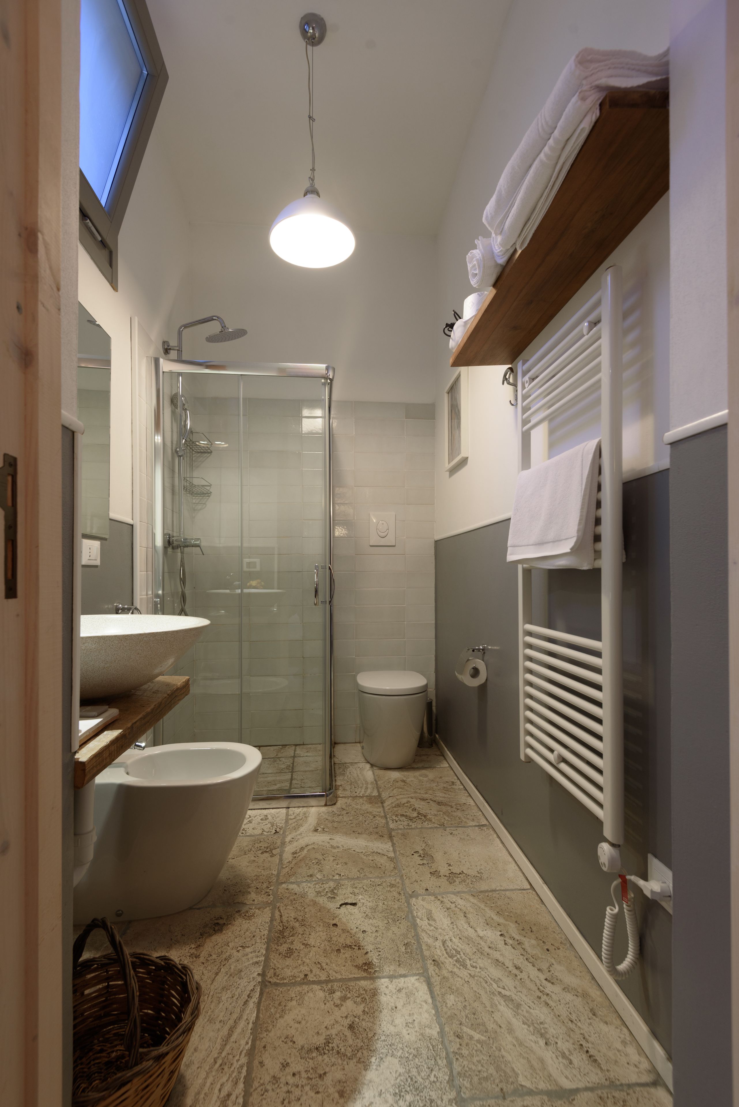 A bathroom with a glass-enclosed shower, a freestanding bathtub, a sink, and a toilet.