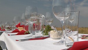 A table set for a meal with wine glasses, a bowl of rice, and red napkins. - Wein & Landhaus Willi Opitz (Illmitz)