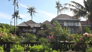 A resort with multiple buildings, surrounded by lush greenery and palm trees. - Sanur Seaview Hotel (Denpasar)