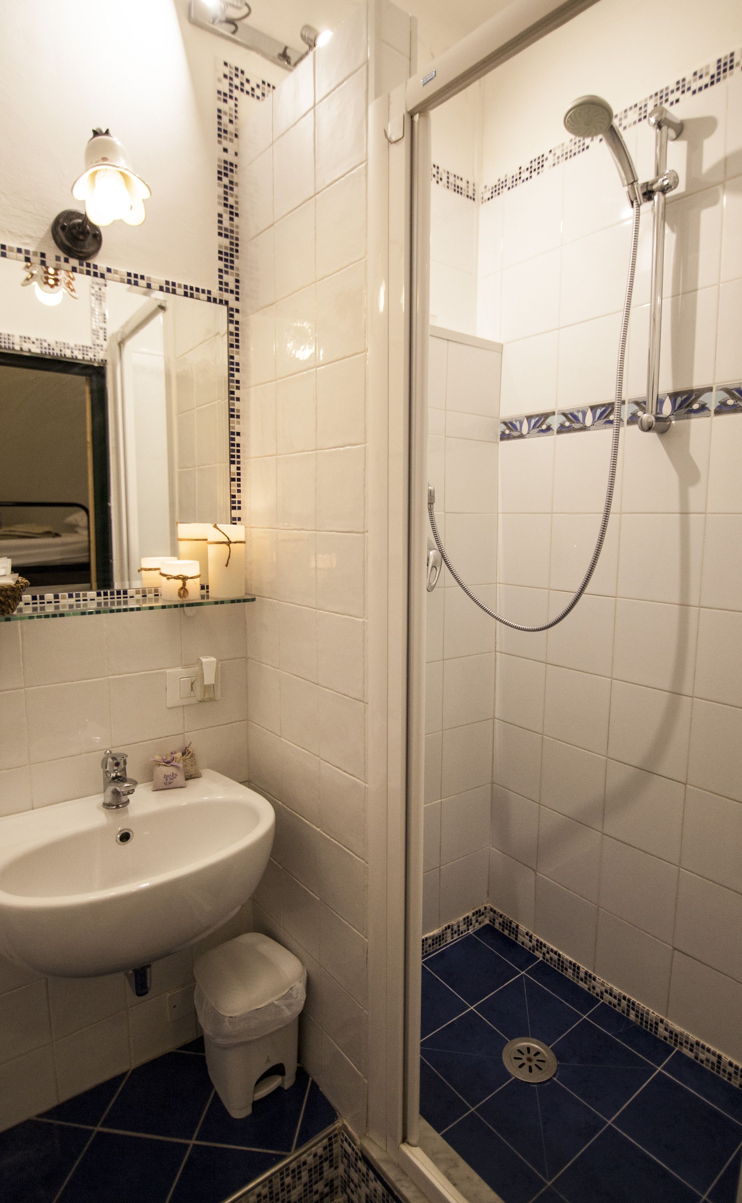 A bathroom with a sink, mirror, and shower.