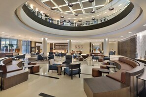 A spacious lobby with a central seating area, multiple levels, and a modern ceiling design. - Four Points by Sheraton Al Ain (Al Ain)