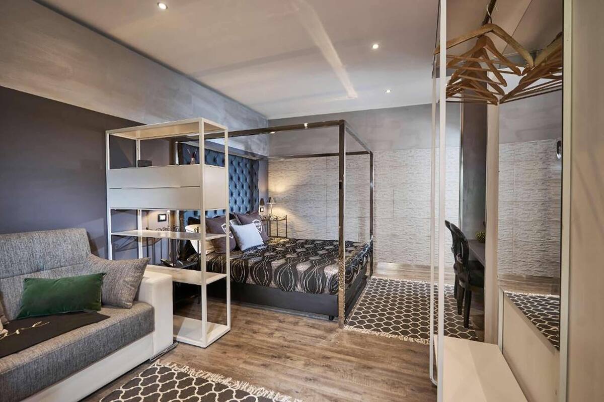 Un dormitorio moderno con una litera, un sofá y un escritorio.