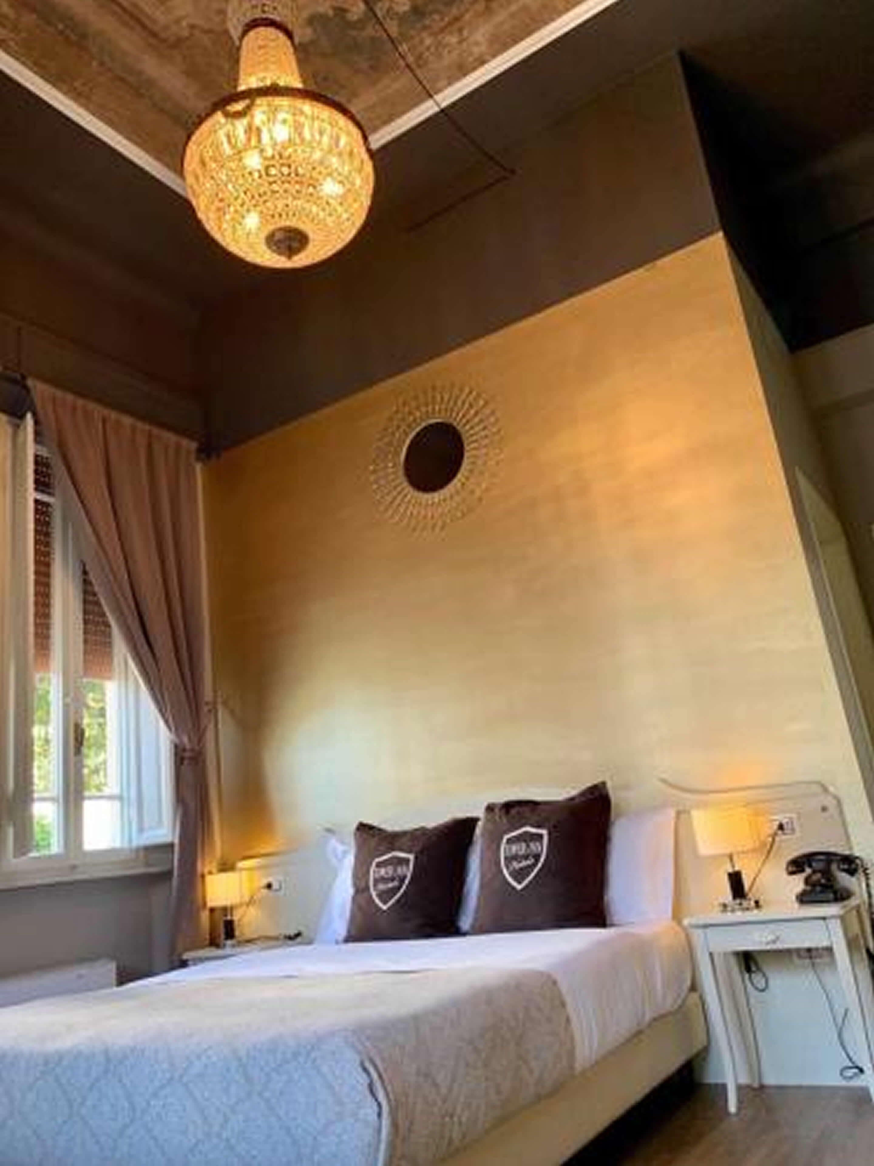 A bedroom with a bed, a nightstand, a lamp, and a ceiling light fixture.