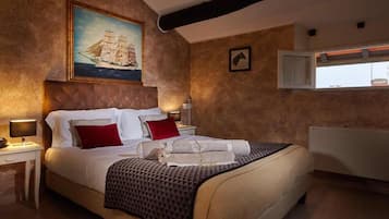 Un dormitorio con una cama grande, un cuadro de un barco, una ventana con persianas y una bañera blanca.