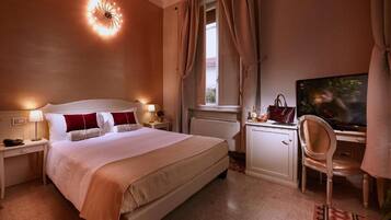 Ein Hotelzimmer mit einem Bett, Nachttischen, einem Schreibtisch mit Stuhl, einem Fernseher und einem Fenster mit Vorhängen.