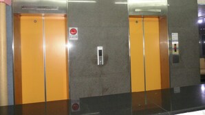 A pair of elevator doors with a no-smoking sign, a control panel, and a digital display. - Modern Plaza Hotel (Kaohsiung)