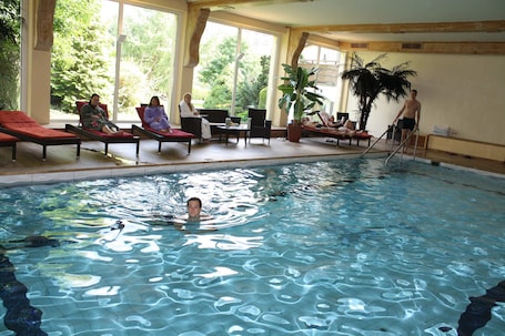 Una piscina techada, sillones reclinables de piscina