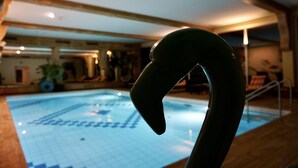 Una piscina con una estructura curva en primer plano.