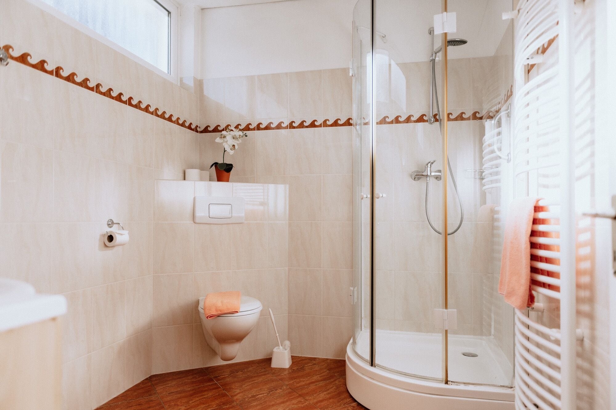 A modern bathroom with a glass-enclosed shower, a toilet, and a sink.