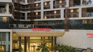 A multi-story hotel with a modern design, featuring a prominent 'MÖVENPICK' sign on the facade. - Mövenpick Enshi (Enshi)