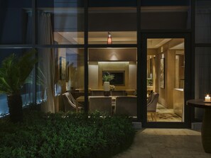 A modern hotel lobby with a seating area, a TV, and a large window.
