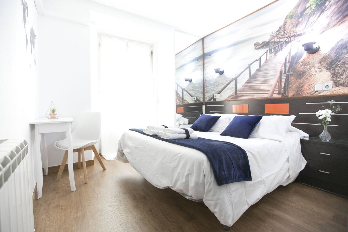 Un dormitorio con cama, escritorio y silla.