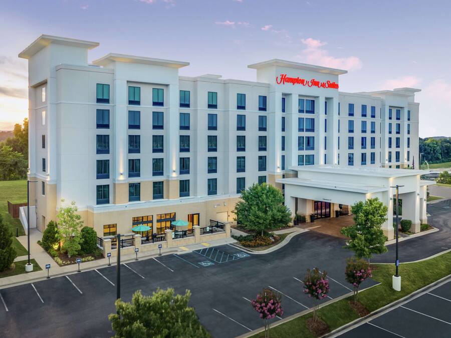 A modern hotel with a flat roof, multiple floors, and a prominent sign.