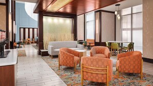 A modern hotel lobby with a wooden ceiling, a seating area with orange patterned chairs, a white sofa, and a large window providing natural light. - Hampton Inn & Suites Chattanooga/Hamilton Place (Chattanooga)
