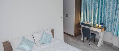 Un dormitorio con cama, escritorio y silla.