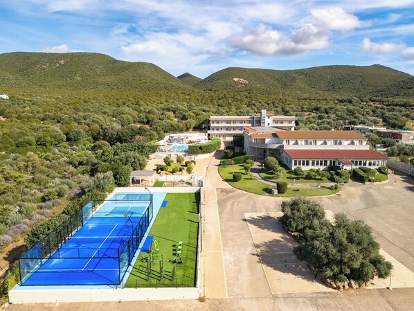 Un grand complexe hôtelier comprenant plusieurs bâtiments, une piscine et un court de tennis.
