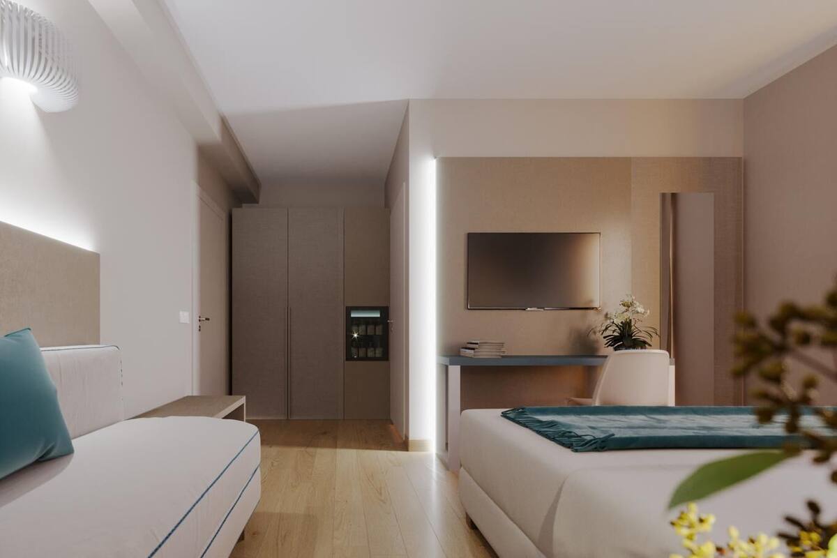 Ein modernes Hotelzimmer mit einer Couch, einem Bett, einem Schreibtisch und einem Fernseher.