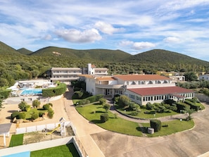 Un resort con varias construcciones, una piscina y un jardín bien cuidado.