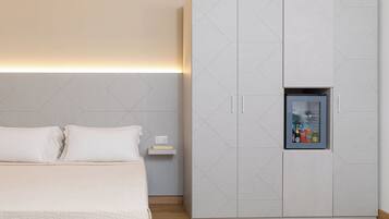 Un dormitorio con cama, armario y repisa con un reloj y botellas.
