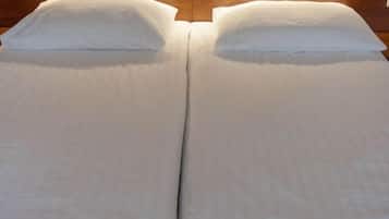 A double bed with wooden headboard and white bedding.