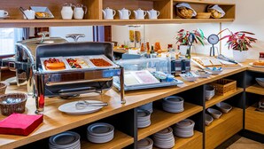 Una mesa de buffet con diferentes tipos de comida y utensilios.