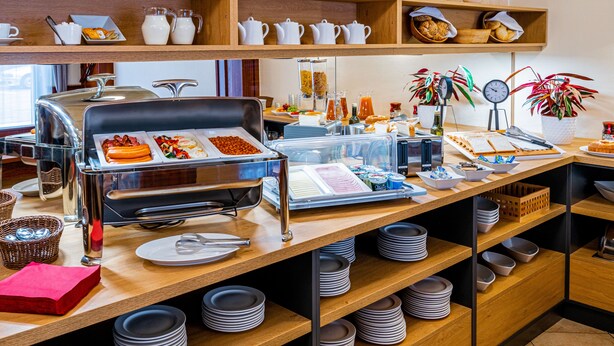 Una mesa de buffet con diferentes tipos de comida y utensilios.