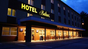 Un hotel con un llamativo letrero que dice 'HOTEL Balti', un área de estar al aire libre cubierta y fachada de ladrillo.