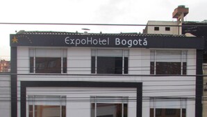 A white van parked in front of a building with a sign reading "ExpoHotel Bogota".