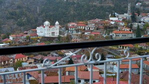 A residential area with a prominent white church with two towers, surrounded by houses with red roofs.