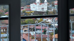 A view of a white building with a red roof, surrounded by a mountainous landscape.