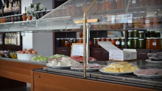A buffet counter with various food items and condiments.