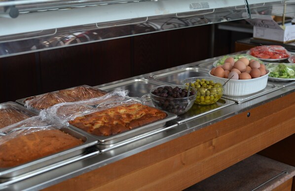 A buffet with various food items including bread, eggs, olives, and vegetables. - Elyssia Hotel (Pedhoulas)