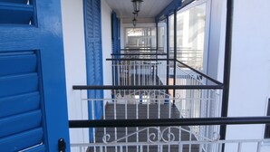 A staircase with blue doors and white railings leading to an upper floor.