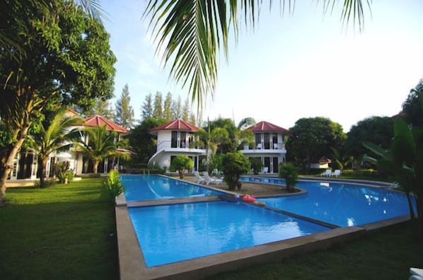 Alberca al aire libre y camastros