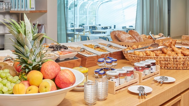 Un bufé de desayuno con frutas, bollería y salsas.