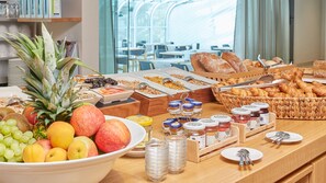 A breakfast buffet with fruits, pastries, and condiments. - Hotel Wettstein (Basel)