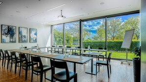 A modern conference room with large windows, wooden flooring, and black chairs. - Hotel Kreuzlingen am Hafen (Kreuzlingen)